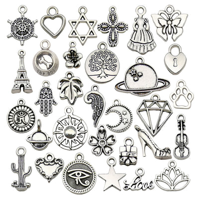 Antique silver butterfly charms arranged on a light background
