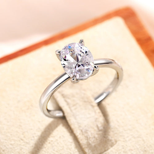Silver-tone oval solitaire ring on a pale ring stand