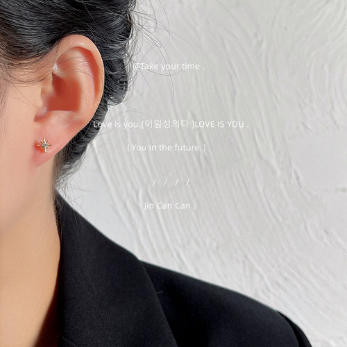 Gold-tone moon-star-pearl five-piece mini studs shown worn on an ear.