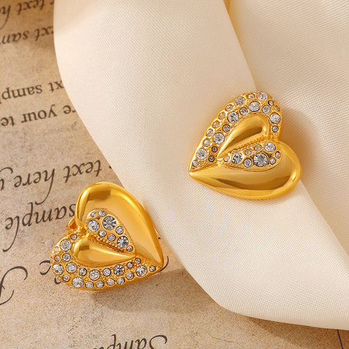 Gold rhinestone paved heart stud pair on cream fabric