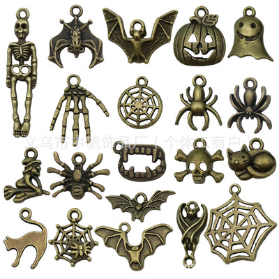 Gold-tone pumpkin and bat charms arranged on a light background