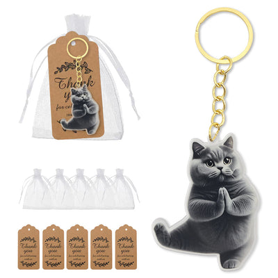 A gray praying cat keychain beside a white organza bag and kraft thank-you tags.