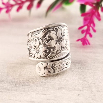 Antique silver embossed lily open wrap ring on marble with pink flowers