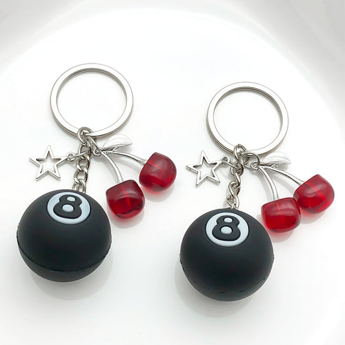 Alternate arrangement of the black eight ball star and cherry metal keychain showing its hardware and charm details