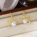 Gold Tone Bow White Pearl Look Ball Huggie Earrings view 6