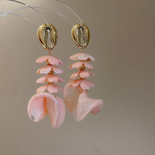 Pink acrylic flower drop earrings with gold cowrie studs and large wave ends