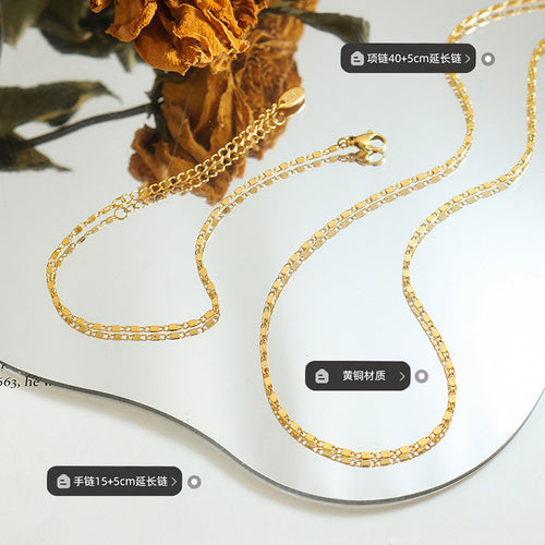 Gold necklace and bracelet flat lay with length and brass labels