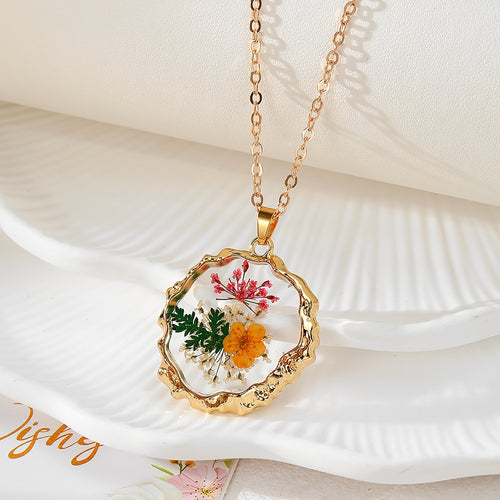 Gold wavy pendant necklace with pink fern yellow daisy and green leaf