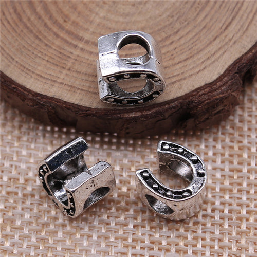 Styled close-up of the horseshoe large hole bead showing horseshoe face with dotted accents