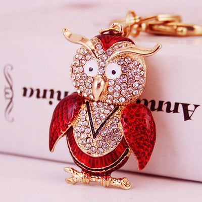 The red owl charm is shown close up with clear rhinestones and gold-tone details.