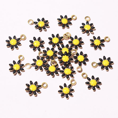 Tiny daisy charms showing assorted shapes and finishes