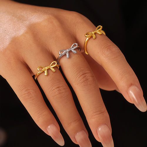 Three bow rings in gold and silver tones on model fingers