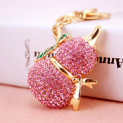 Close-up of a pink rhinestone double-gourd charm attached to gold-tone key hardware.