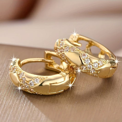 Pair of gold cross pave huggie hoops showing hinge and latch detail