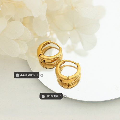 Pair of gold geometric huggies on mirror with plating label