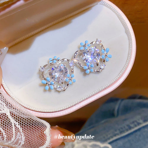 Pale blue floral clusters framed by small clear heart outlines in a close product view.