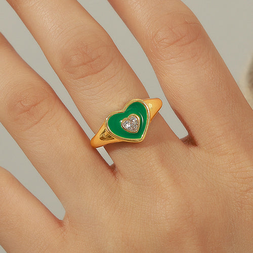 Green heart enamel gold ring on finger close-up