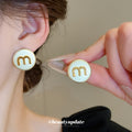 Cream Round Stud Earrings with Gold Letter M Detail view 1