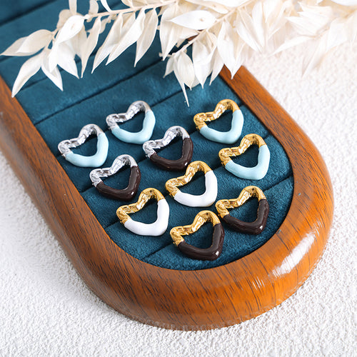 Assorted blue white brown heart enamel studs on teal jewelry tray
