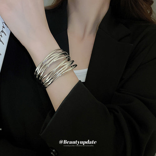 wide multi-bar crossing open cuff bracelet in gold-tone or silver-tone finishes shown worn in a styled second view