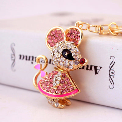 Close-up of a pink rhinestone mouse charm with a curled tail and bow detail.