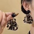 Black Leopard Floral Resin Drop Earrings with Polished Details view 1