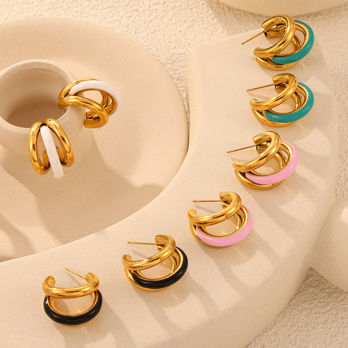 Four color gold double C enamel hoop pairs on beige ceramic display