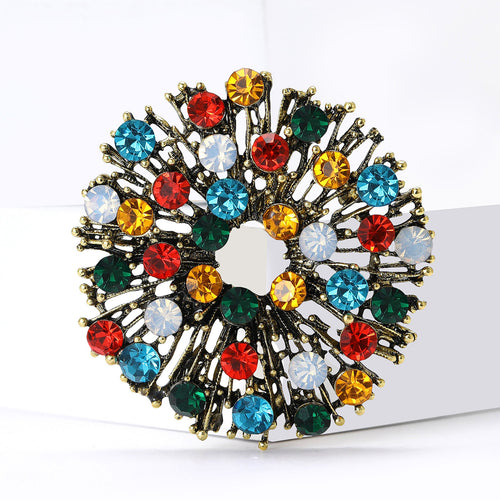 Multicolor crystal round brooch angled on white blocks