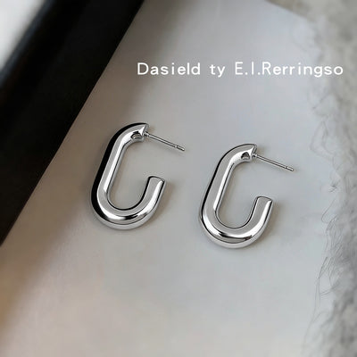 Silver hollow tube U-shape hoop studs on pale fabric with posts visible