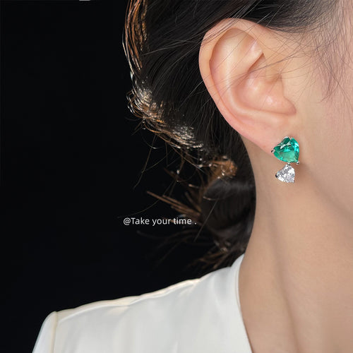 Model wearing green heart stud with clear heart drop earring