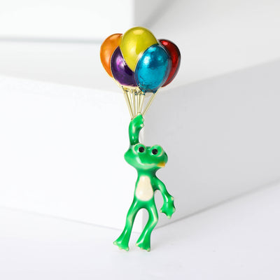 Balloon Frog brooch styles arranged on a light display