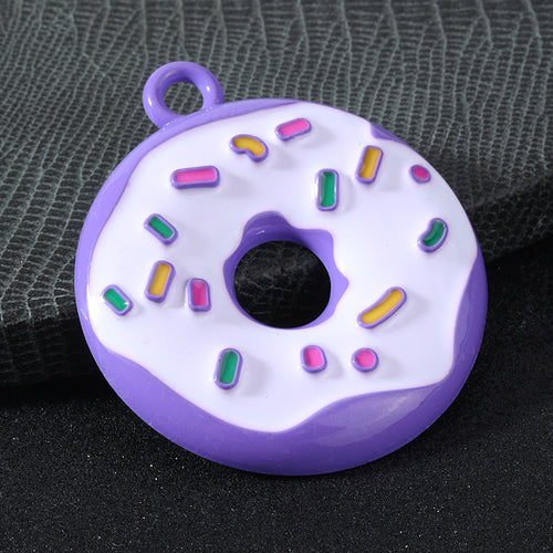 Close-up of a purple donut charm with colorful sprinkles and a metal hanging loop