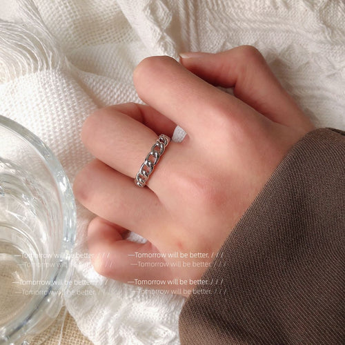 Silver-tone interlocking-chain-link open ring shown worn on an ear.