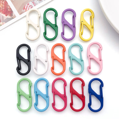 Colorful spring clasp jewelry findings arranged on a light background