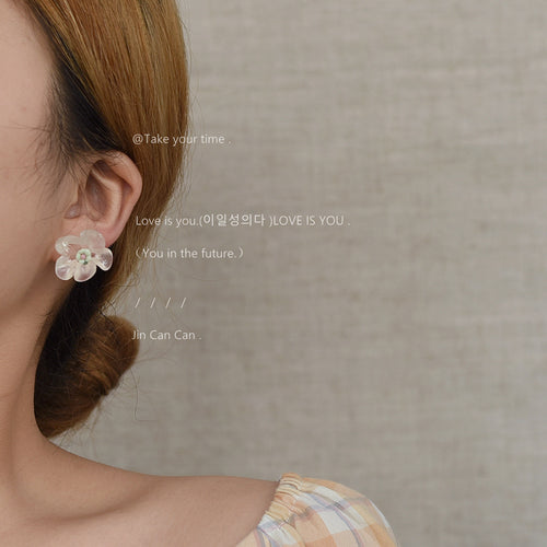 Model wearing clear translucent flower stud on ear side profile