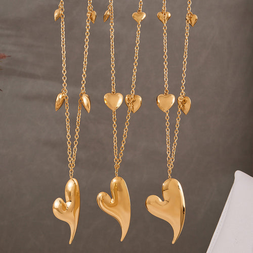 Neckline view of long asymmetrical heart station necklaces in main image 2.
