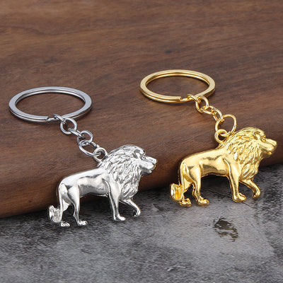 Silver-tone and gold-tone lion keychains displayed together on a wood surface.