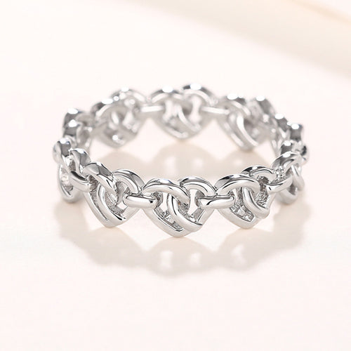 Close front view of interlocking heart links on white metal band