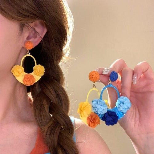 A styled close view of the woven flower hoop earrings.