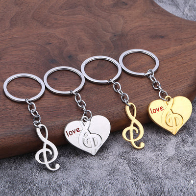 Silver-color and gold-color music-themed keychain pairs arranged together on a wood surface.