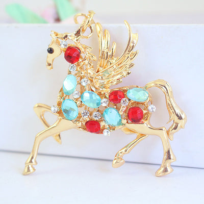 A red and aqua stone winged horse charm is shown in close-up.