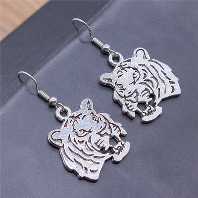 Close view of cutout tiger head drop earrings in two antique finishes