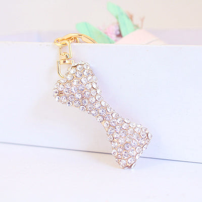 Angled front view of a clear rhinestone bone charm hanging from gold-tone hardware.