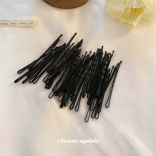 black wavy bobby hair pins shown in a multipiece group shown in the first close product view