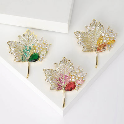Three gold maple leaf brooches green pink yellow variants