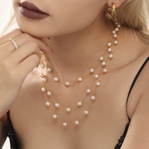 Three layered gold station shell pearl necklaces close-up on model