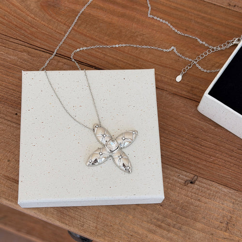 Silver Tone Four Point Starburst Pendant Long Necklace shown in a display view
