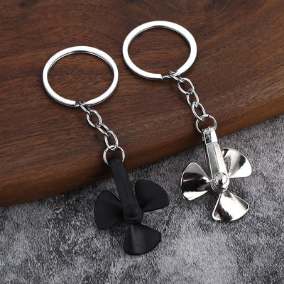 Black and silver three-blade propeller keychains displayed side by side.