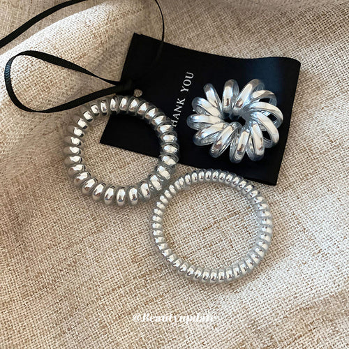 silver metallic spiral coil hair tie in the listed medium style shown in the first close product view