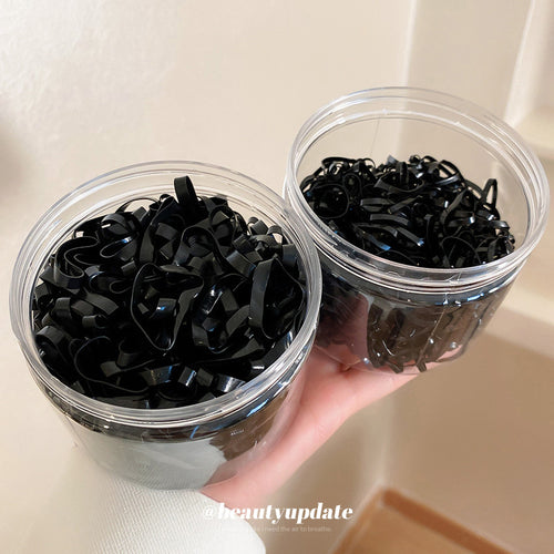 black elastic hair ties packed in clear plastic jars shown worn in a styled second view